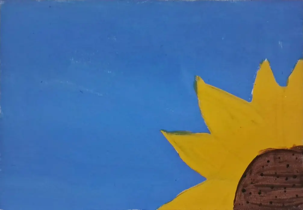 Parte de um girassol amarelo no canto inferior direito de um fundo azul.